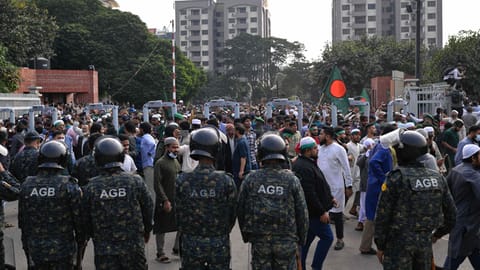 Security forces stand guard at the entrance of nation's Parliament complex as people arrive to perform funeral prayers for leading Bangladeshi activist Sharif Osman Hadi, who died from gunshot wounds sustained in an attack in Dhaka earlier this month, in Dhaka, Bangladesh