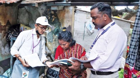 Booth-level officer (BLO) distributing the SIR forms to the public.