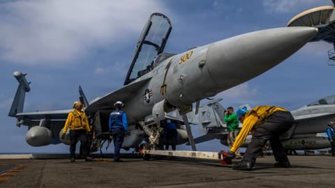 Sailors preparing a Boeing EA-18G Growler on the flight deck of the Nimitz-class aircraft carrier USS Abraham Lincoln in the Indian Ocean