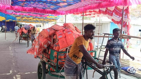 Fishermen carry life jackets on tricycles to be loaded onto barges for the safe passage of devotees going to Kachchathivu festival