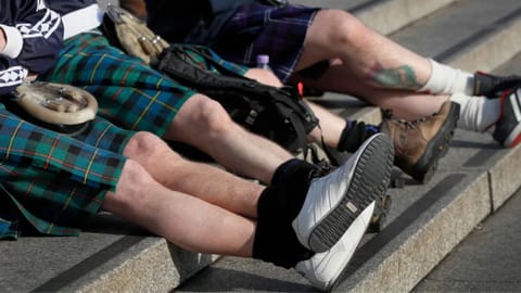 Scottish soccer fans wearing kilts sit on the steps in Trafalgar Square after attending a service to mark Armistice Day in London