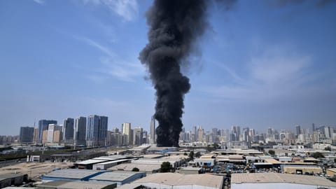 A black plume of smoke rises from a warehouse at the industrial area of Sharjah City in the United Arab Emirates following reports of Iranian strikes in Dubai, United Arab Emirates, Sunday, March 1, 2026.