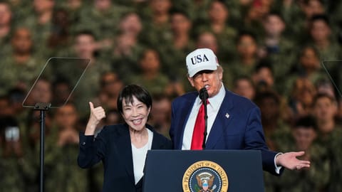 Japanese Prime Minister Sanae Takaichi gestures as U.S. President Donald Trump delivers his speech during their visit to the aircraft carrier USS George Washington at the U.S. Navy’s Yokosuka base in Yokosuka, south of Tokyo, on Oct. 28, 2025