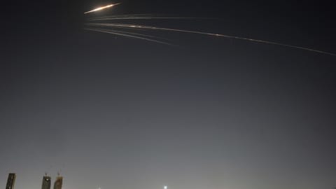 Missiles launched from Iran streak across the sky over central Israel