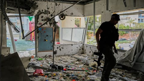 An Israeli policeman walks in a kindergarten hit by fragments of an Iranian missile in Rishon LeZion, Israel, Saturday, March 21, 2026.