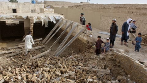 Locals inspect a damaged house following floods, landslides and thunderstorms in Kandahar province, Afghanistan, Sunday, March 29, 2026.