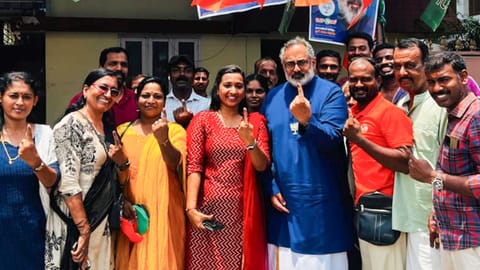 Kerala BJP President Rajeev Chandrasekhar, centre, shows his ink-marked finger with party workers after casting vote during the state Assembly elections, in Thiruvananthapuram