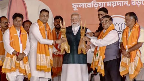 Prime Minister Narendra Modi, centre, being felicitated during a public meeting ahead of West Bengal Assembly elections