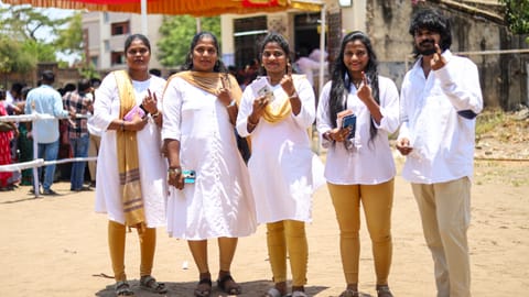 A group of youngsters in TVK's signature attire at a booth in Pulianthope
