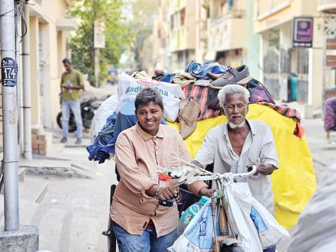 An elderly cycle cart puller hauls house-shifting loads