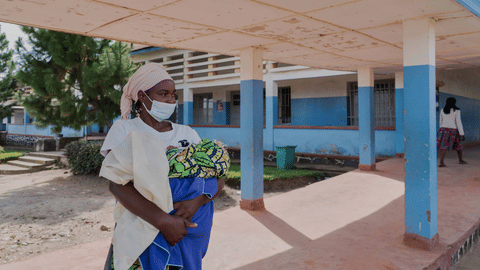 A woman wearing a protective mask stands in the corridor of a hospital in Bunia, Congo