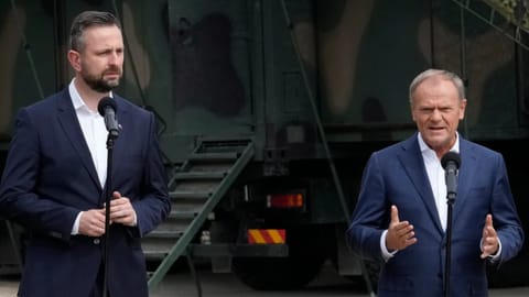 Poland's Prime Minister Donald Tusk, right, and Defense Minister Wladyslaw Kosiniak-Kamysz, visit troops who patrol Poland's border with Belarus, in Dubicze Cerkiewna, eastern Poland