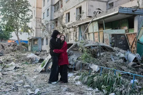 People react as they look at the site of a Russian missile strike that hit a residential building in Kyiv, Ukraine