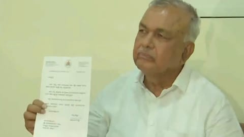 Karnataka minister Ramalinga Reddy showing his Resignation letter to the media