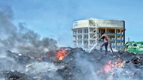 A firefighter dousing blaze at the Pallikaranai dump yard, where
abandoned vehicles were also gutted | Photo: Justin George