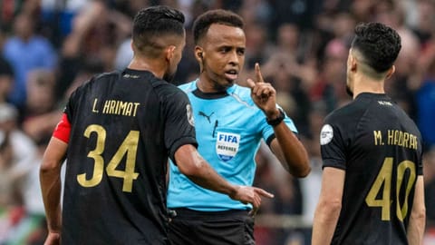 Referee Omar Artan, center, of Somalia, is confronted by players after calling a penalty kick during the CAF Champions League final soccer match between AS FAR Rabat and Mamelodi Sundowns
