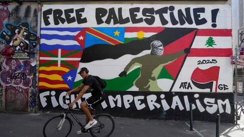 A man rides his bicycle in front of a mural, ahead of expected protests for the G7 summit, in Geneva, Switzerland