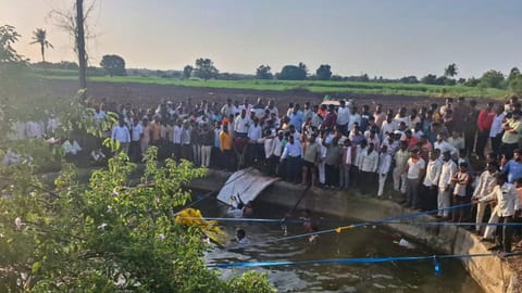 People gather after a pickup-vehicle plunges into a roadside well, in Solapur, Maharashtra
