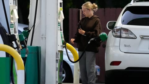 Customer checks gas price before she fills up her vehicle's tank at a gas station in Lincolnshire