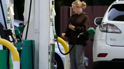 Customer checks gas price before filling her vehicle's tank in gas station