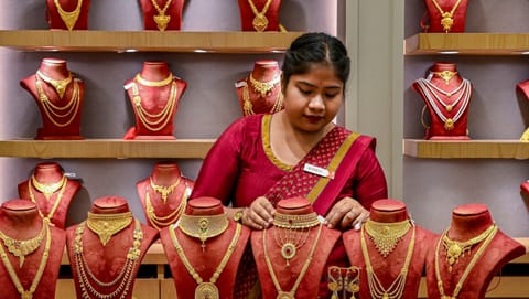 A vendor displays gold jewellery for sale at a store