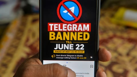 A man checks his mobile phone displaying information related to the temporary restriction on the messaging application Telegram ahead of the NEET-UG re-examination, in Siliguri