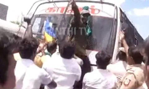 A PMK supporter climbing on the police van. Thanthi TV screengrab