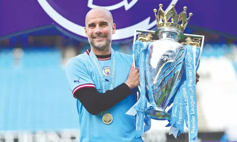 Pep Guardiola poses with the EPL trophy.