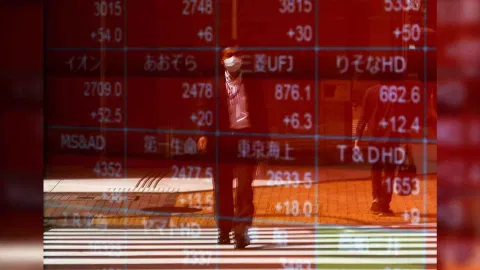 A man is reflected on an electric stock quotation board outside a brokerage in Tokyo, Japan (Photo: Reuters) 