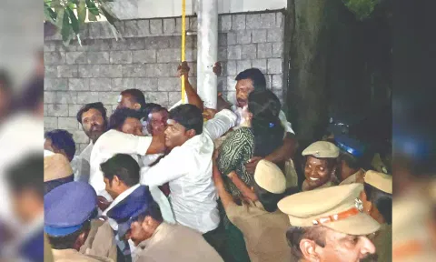 BJP cadre preventing police from removing flagpole in Chennai.