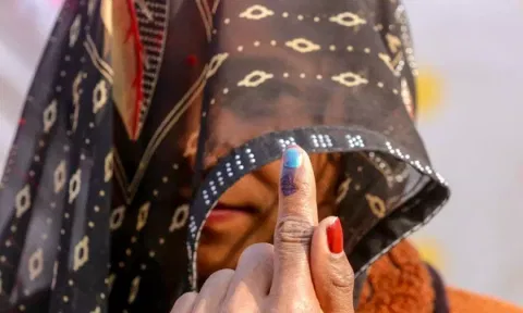 A female voter in veil shows her finger marked with indelible ink after casting a vote (ANI) 