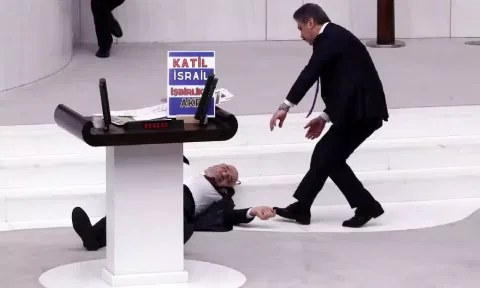  Turkey's opposition Felicity Party lawmaker Hasan Bitmez lies on the floor next to a stand with a placard after collapsing