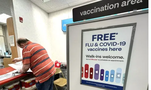  A sign for flu and covid vaccinations is displayed at a pharmacy store in Palatine, Ill