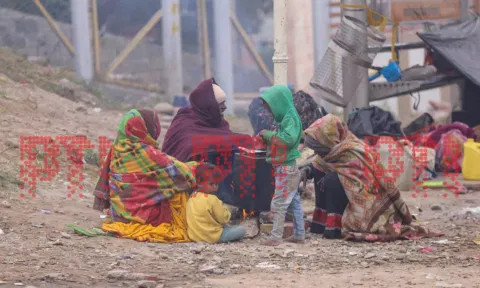  People sit near an earthen stove to warm themselves during a cold winter morning, in Jammu, Saturday. (PTI)