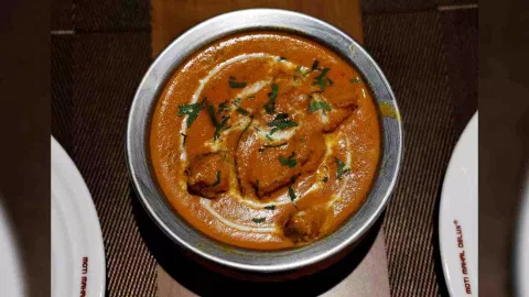A freshly prepared butter chicken dish is placed on a table inside the Moti Mahal Delux restaurant in New Delhi, India. (Reuters)