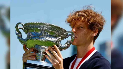 Italy's Jannik Sinner poses with the Australian Open trophy (Reuters)