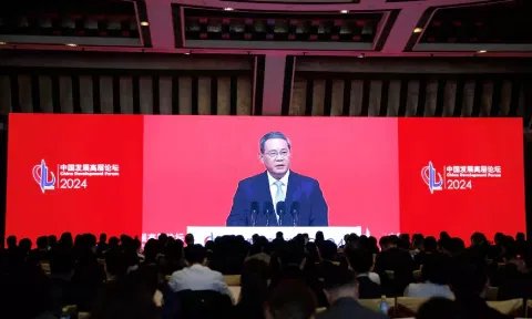 Journalists watch a giant screen showing live-streaming footage of Chinese Premier Li Qiang delivering a speech at the opening ceremony of China Development Forum (CDF) 2024, in Beijing, China March 24, 2024. (REUTERS)