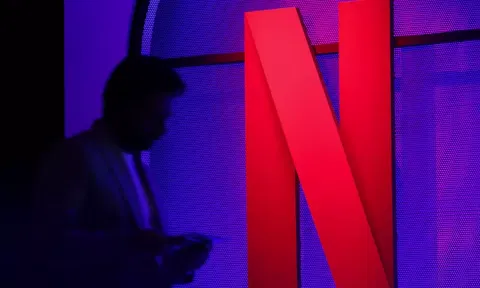  A man stands next to a logo of Netflix (Reuters)