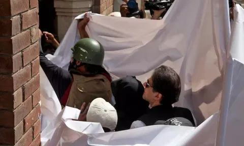  Imran Khan and his wife Bushra Bibi are covered with a white sheet(Image: Reuters) 