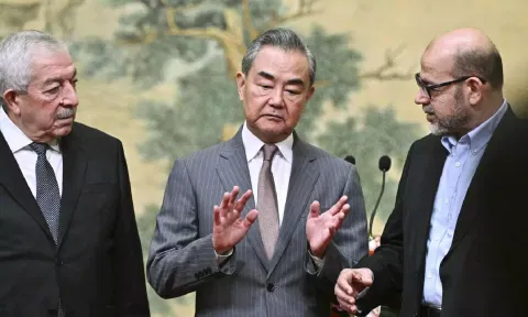 China's Foreign Minister Wang Yi, center, hosts an event for Mahmoud al- Aloul, left, vice chairman of Fatah, and Mussa Abu Marzuk, a senior member of Hamas, to meet at the Diaoyutai State Guesthouse in Beijing, 