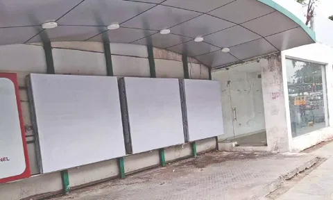 Locked up AC bus stop at Asargana and adjacent open area without seats