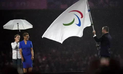 President of the International Paralympic Committee Andrew Parsons passes the Paralympic flag to Mayor of Los Angeles Karen Bass (AP)