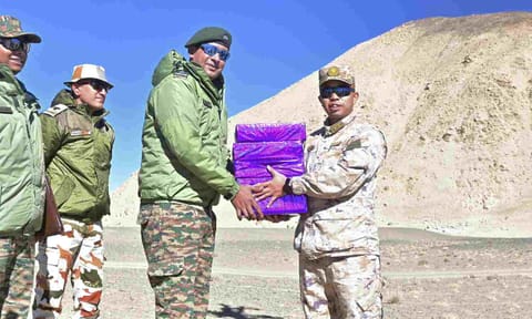 Indian and Chinese Army personnel exchange sweets on the Diwali festival, at a border point along LAC (PTI) 