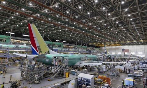  Boeing employees work on the 737 MAX on the final assembly line at Boeing’s Renton plant (AP)