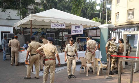 Police and security personnel stand guard a barricaded road near a counting center amid the counting of votes for the Maharashtra Assembly elections (PTI)