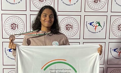 Deeksha Sivakumar poses with the medal she won 