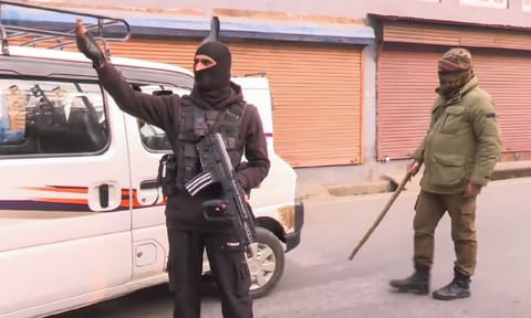 Security personnel stand guard on a road amid a joint operation by Indian Army & J&K Police, in Srinagar