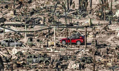 A car drives past homes and vehicles destroyed by the Palisades Fire at the Pacific Palisades Bowl Mobile Estates (AP) 