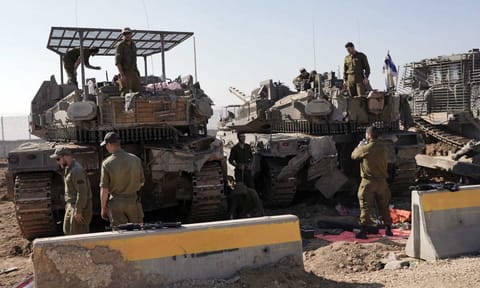 Israeli soldiers work in a staging area on the Israel-Gaza border after returning from the Gaza Strip on Jan 18,2025, a day ahead of a ceasefire between Israel and Hamas (AP) 