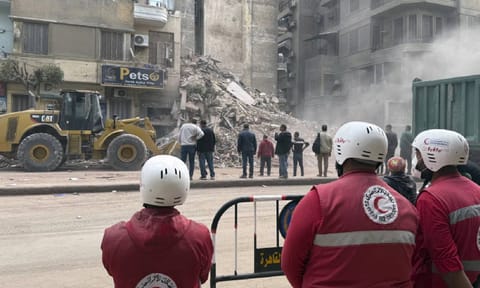 Rescuers search through the rubble of a collapsed six-story apartment building in Cairo (AP) 
